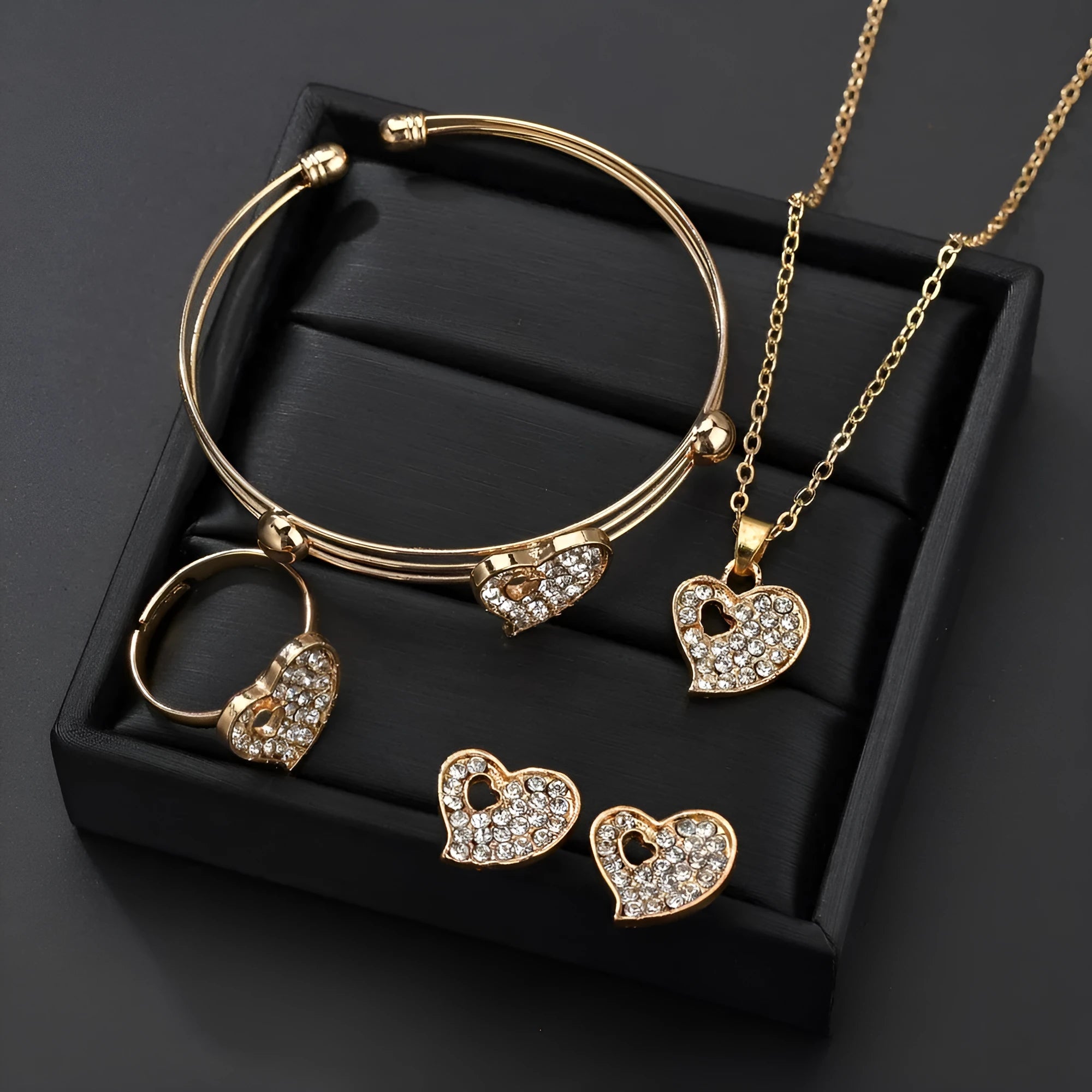 Gold-colour women's jewellery set with earrings, adjustable necklace and bracelet featuring heart, water drop and bell charms.