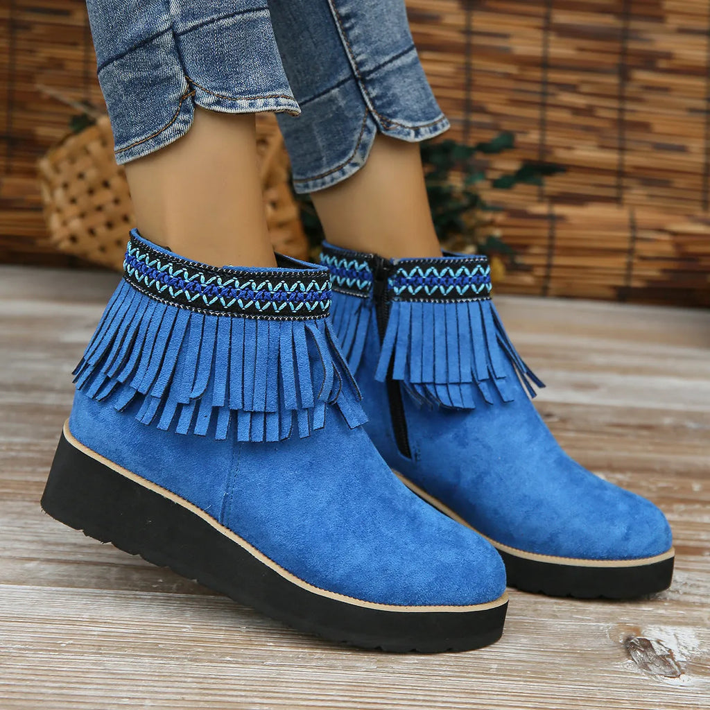 Women's dark brown suede ankle boots with a wedge heel, side zip, and decorative tassel detail.