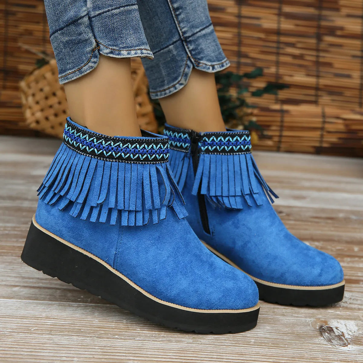 Women's dark brown suede ankle boots with a wedge heel, side zip, and decorative tassel detail.