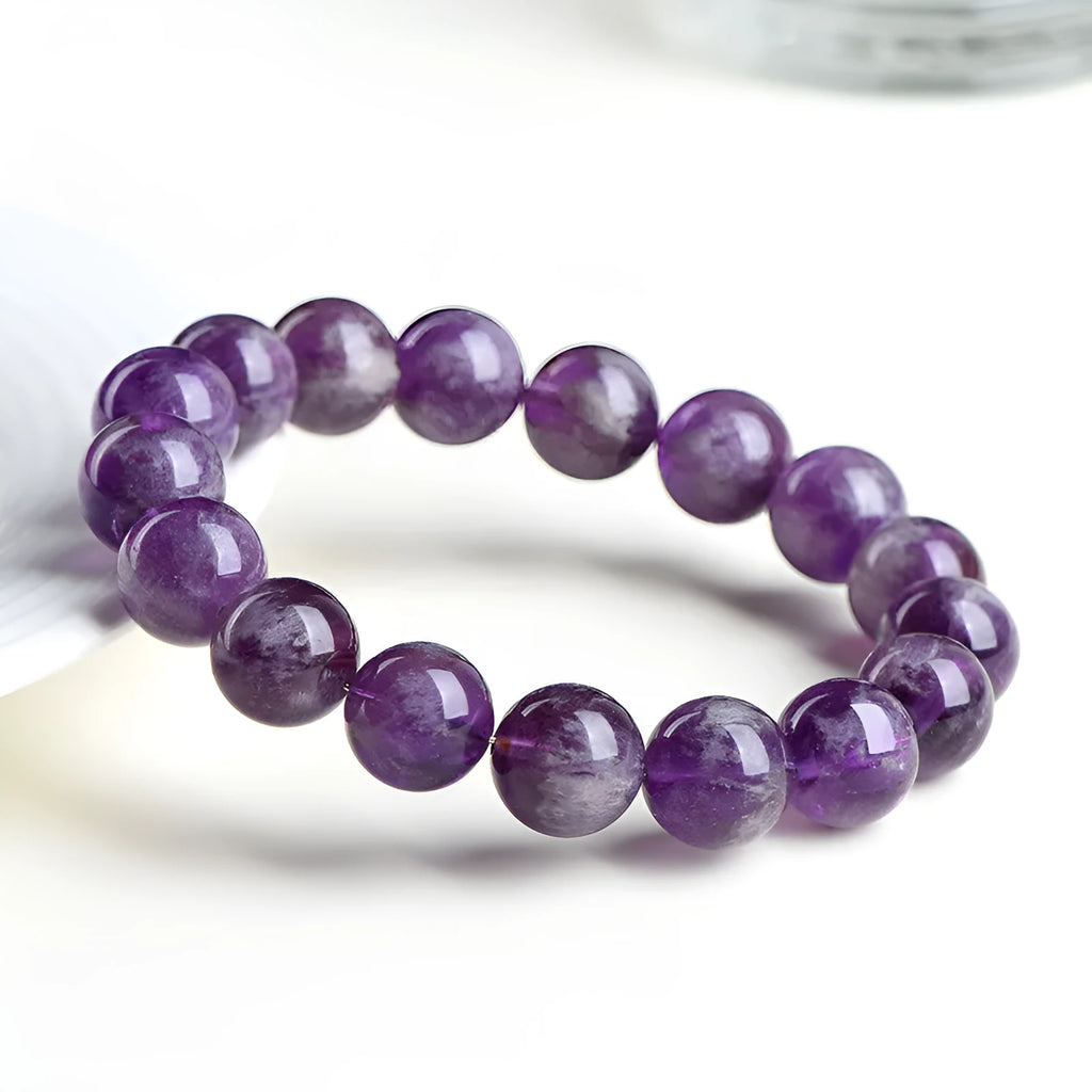 Natural feather amethyst crystal bracelet with geometric shape and silver fastener on wrist.