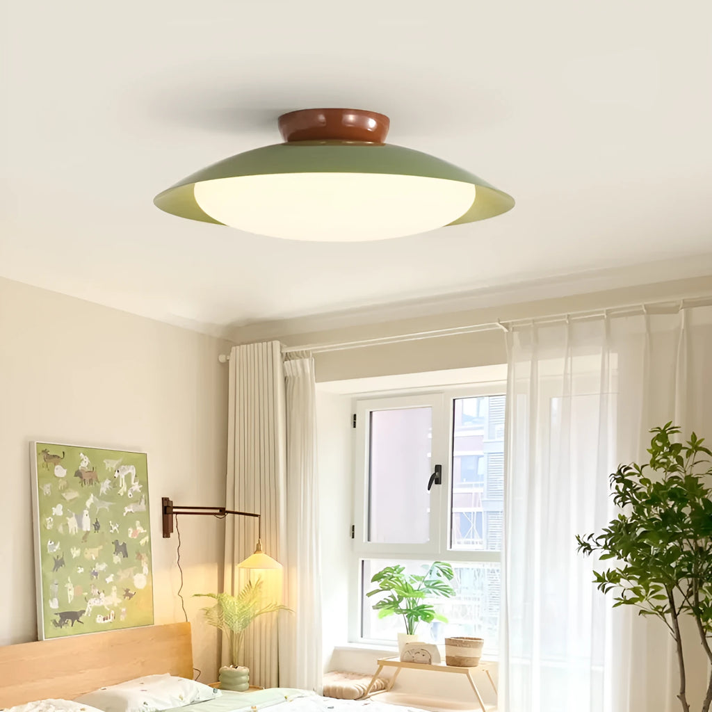 Modern flying saucer shaped ceiling lamp with an iron shade, shown in a cream yellow finish.
