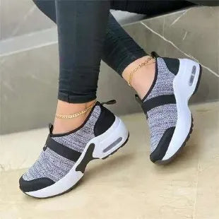 Women's flat mesh sneakers in light grey with white rubber soles and colour stitching.