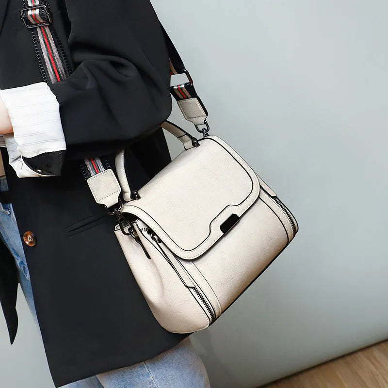 Women's brown genuine oil wax leather messenger bag with double strap and external pocket.