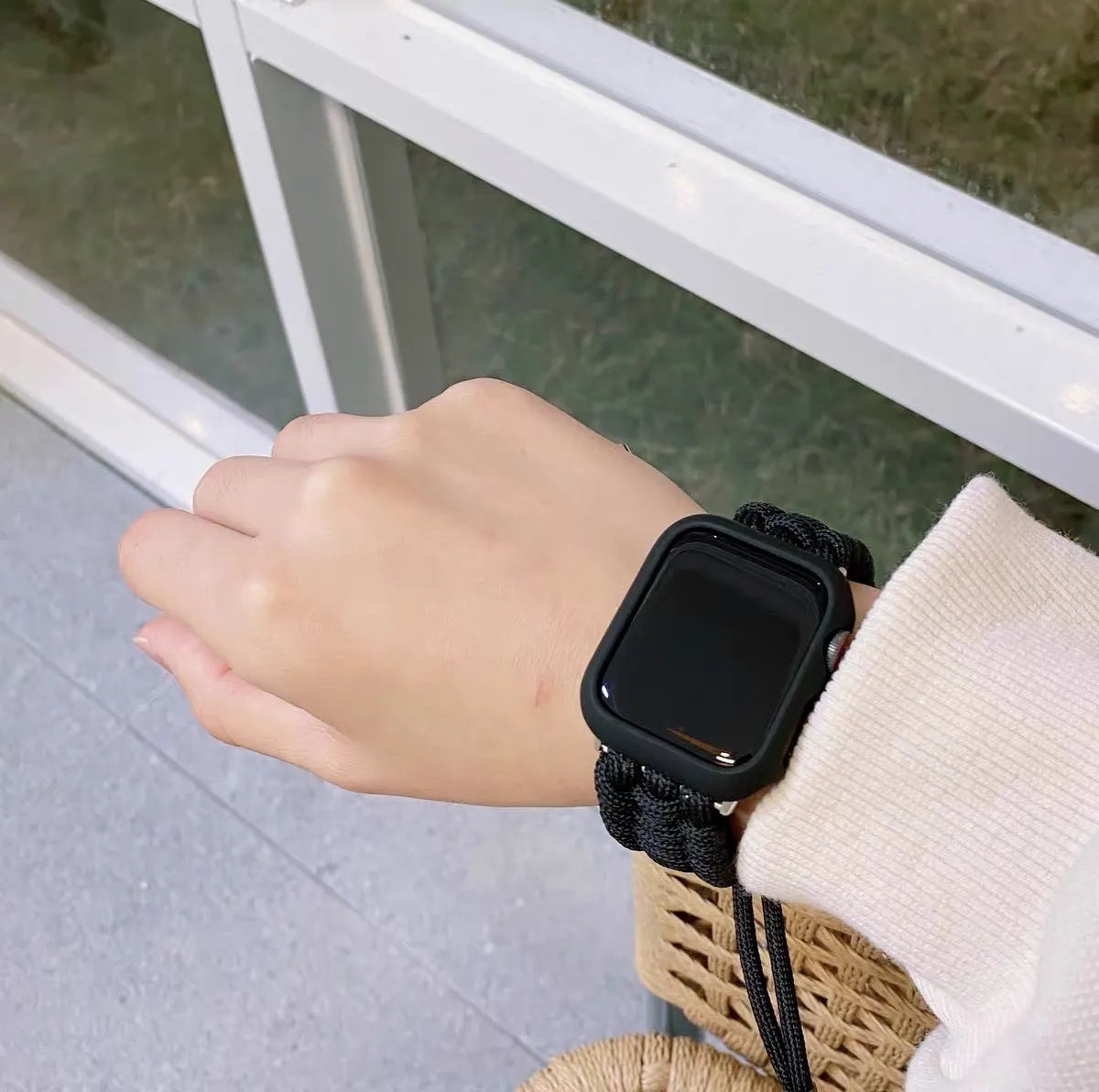 Braided paracord smart watch strap in black, shown detached from a watch, with standard connector lugs.