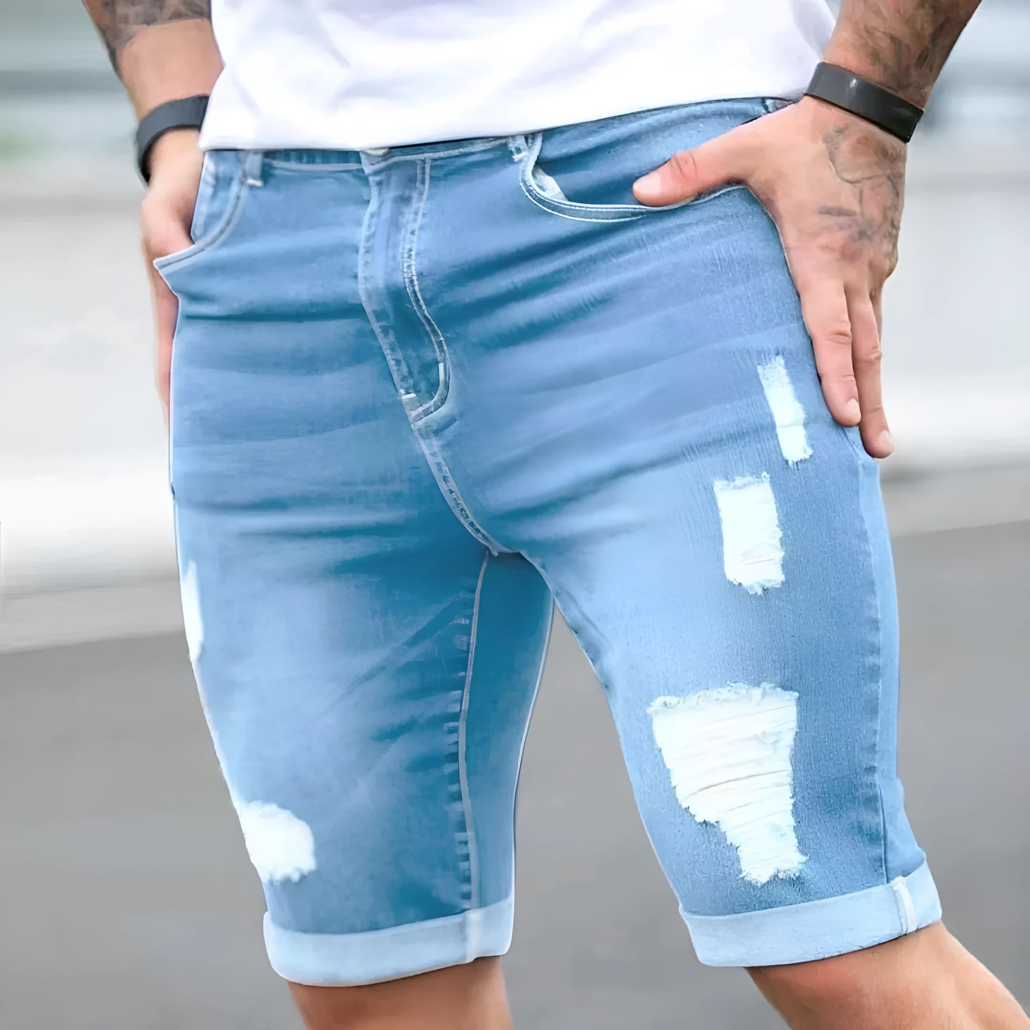 Sky blue denim shorts with multiple distressed holes and straight leg silhouette