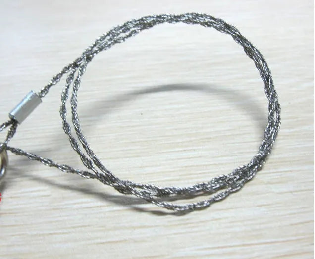 55cm stainless steel survival wire saw with pull rings and hoops on a green background.