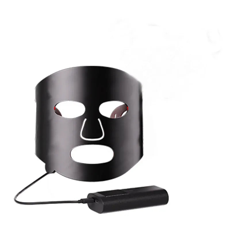 Black and white LED phototherapy face mask with controller for home skin treatment.
