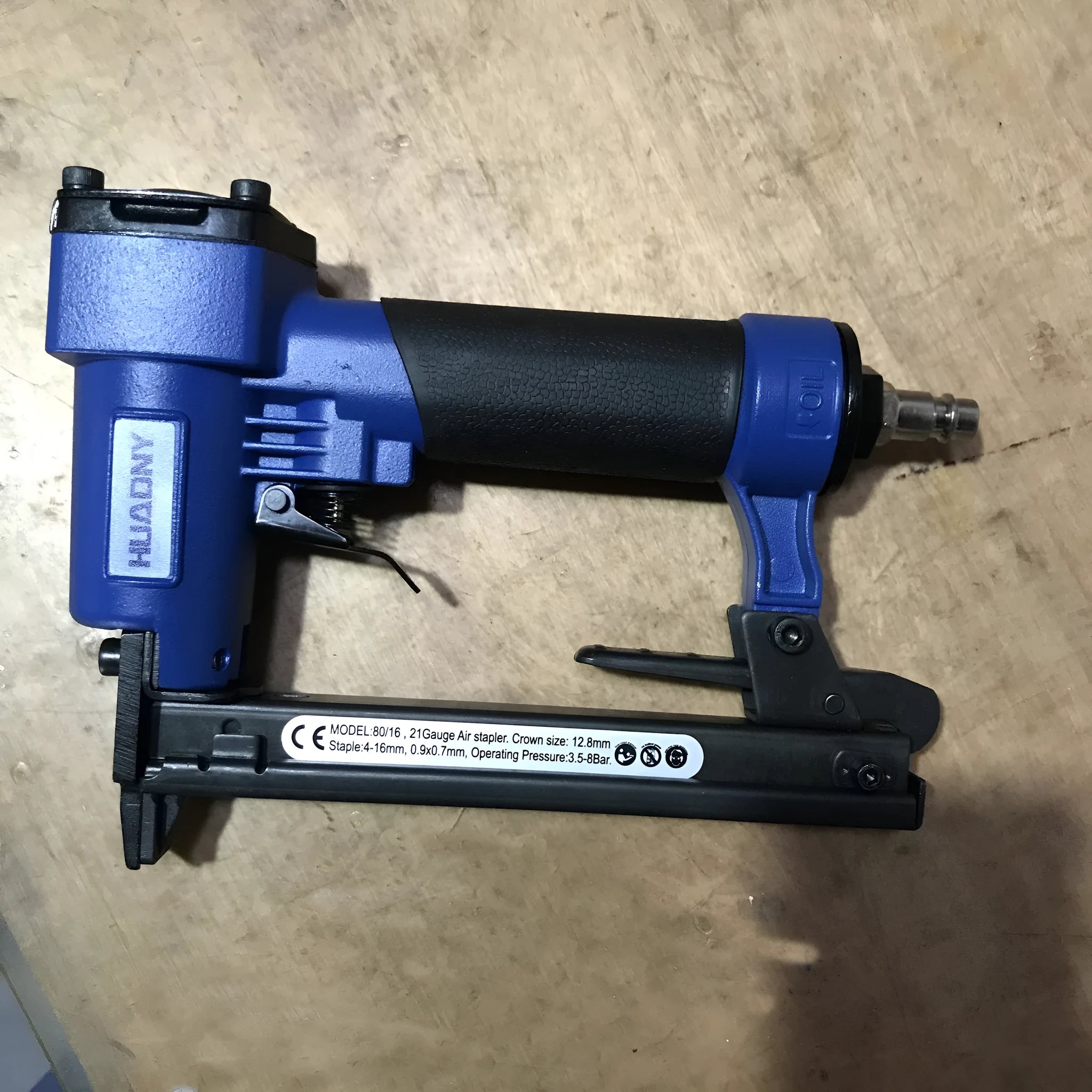 Blue and yellow U-type pneumatic strip nail gun with American connector for furniture and interior work.