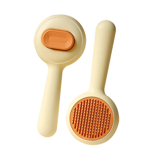 Green and yellow plastic cat brush with stainless steel teeth and a non-slip handle.