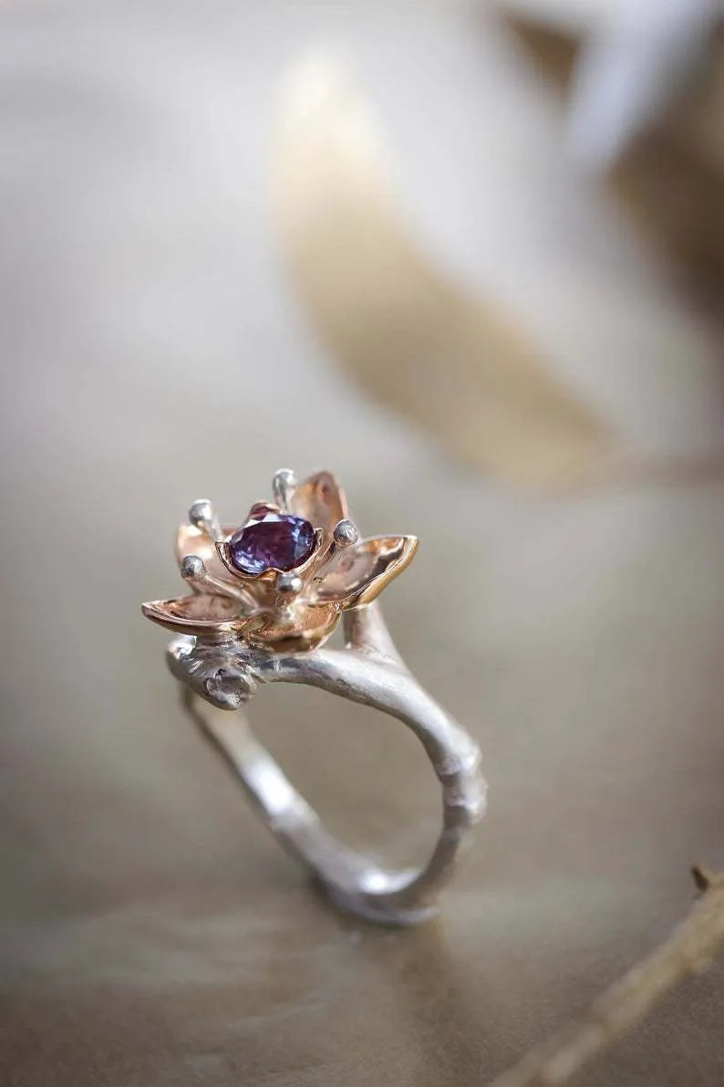 Silver and rose gold two-tone floral design alloy ring on a geometric band.