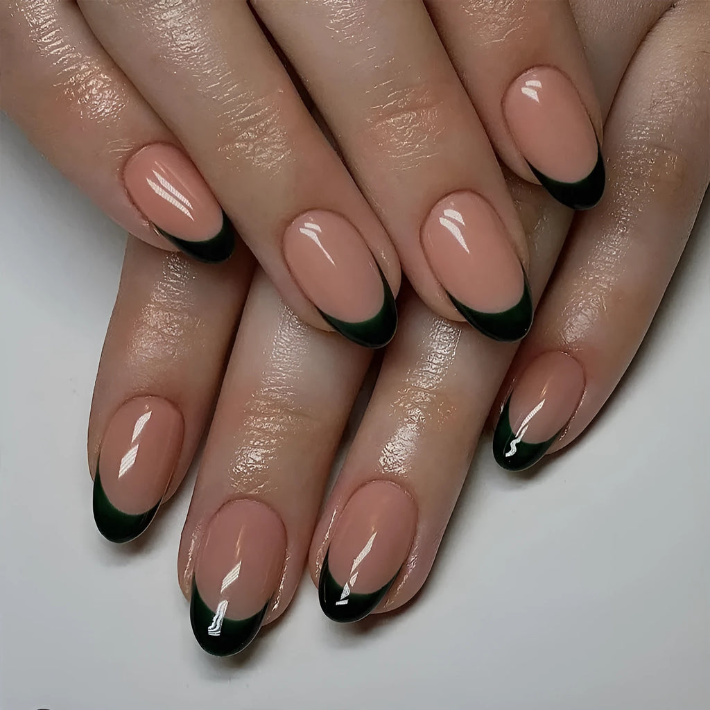 Short almond shaped false nails with black French tips, set of 24 pieces laid out.
