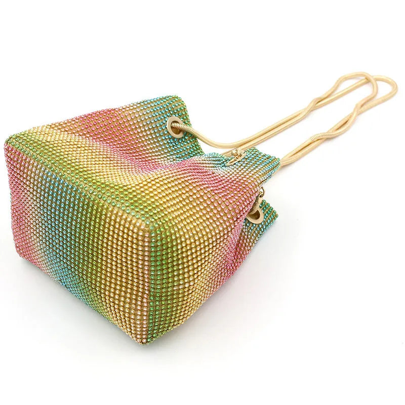 Colourful rhinestone fabric bucket bag with a sparkling jewelled shoulder strap on a white background