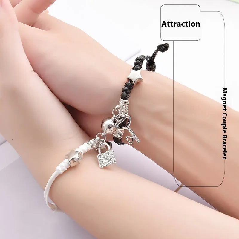 Pair of magnet couple bracelets with suction clasp on wrist, showing alloy designs like crown and love lock.