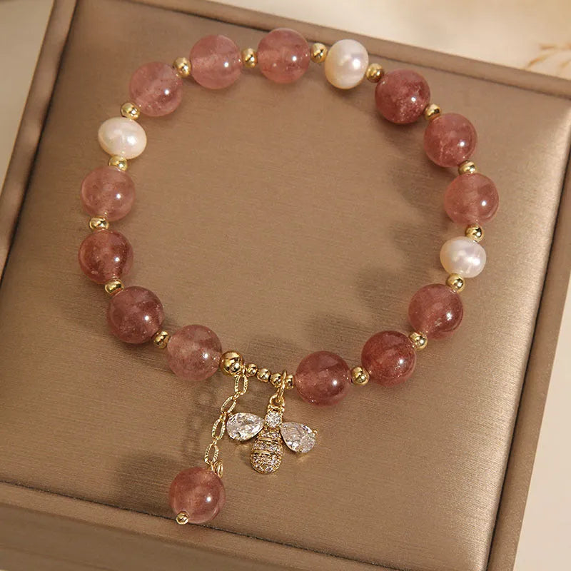 Strawberry quartz and freshwater pearl bracelet with zircon accents on woman's wrist