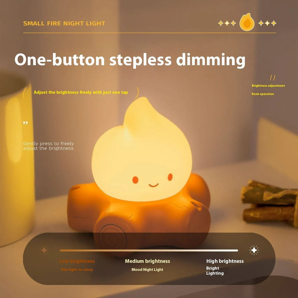 Silicone cartoon fire pile night light with yellow LED illumination on a bedside table.