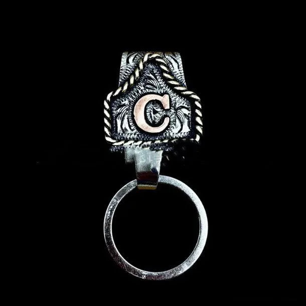 Handmade metal cow tag belt key holder keychain on a key ring, showing the metal loop and tag design.