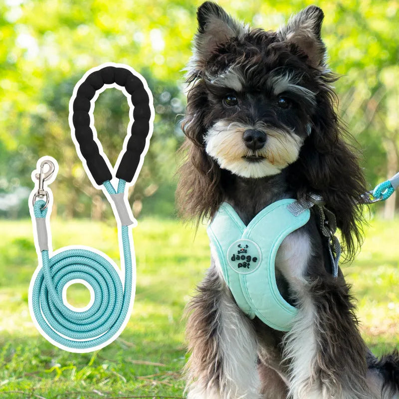 Blue polyester dog vest harness with an attached hand-held rope for walking.