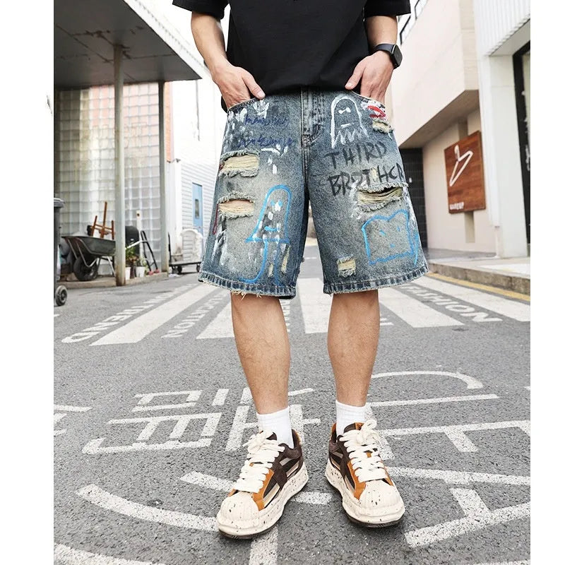 Blue ripped denim jeans shorts for men with graffiti design and straight leg opening.
