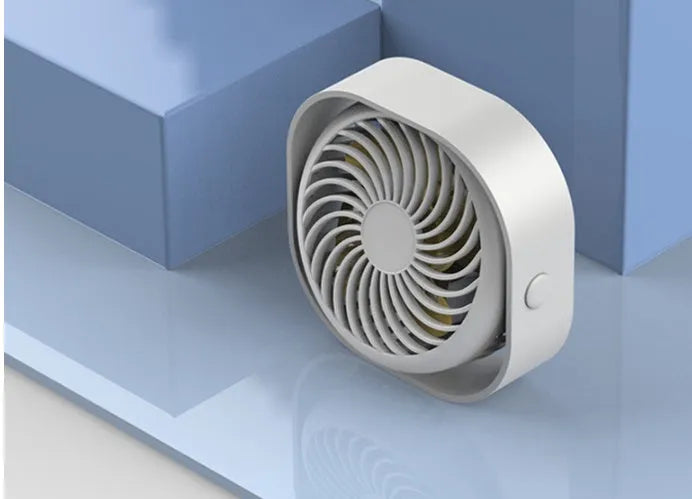 USB desk fan with rotating head in modern alarm clock style on a desk.