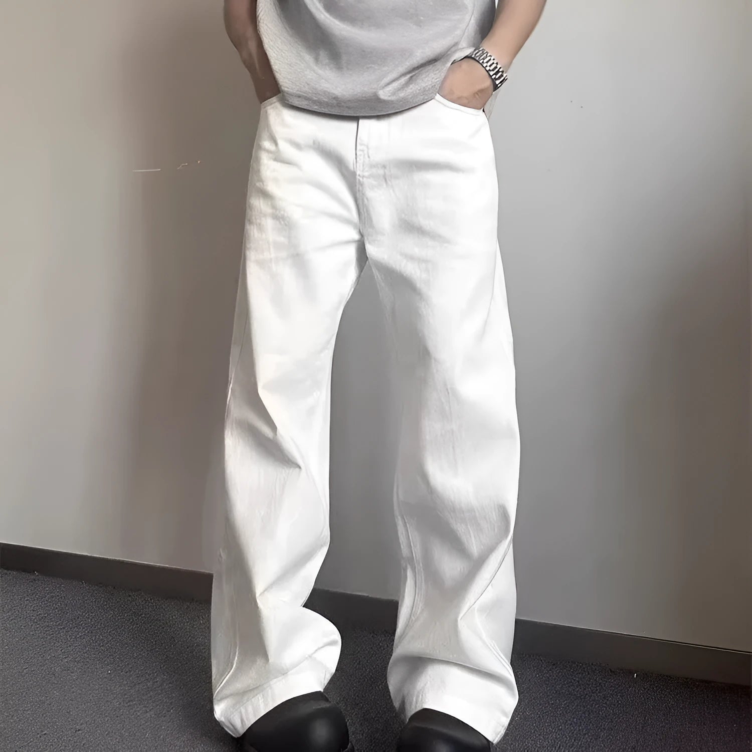 A pair of men's white wide-leg straight jeans with a mid-rise waist and zipper fly on a plain background.