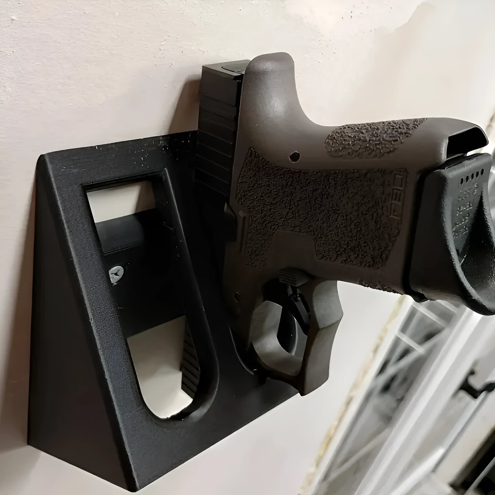 Black punk-style plastic pistol stand for handgun display measuring 10.85cm by 7.6cm
