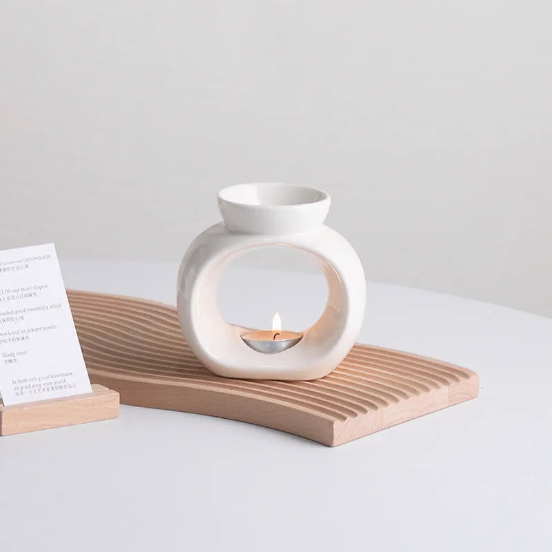 White ceramic Nordic-style aromatherapy stove ornament on a wooden surface.
