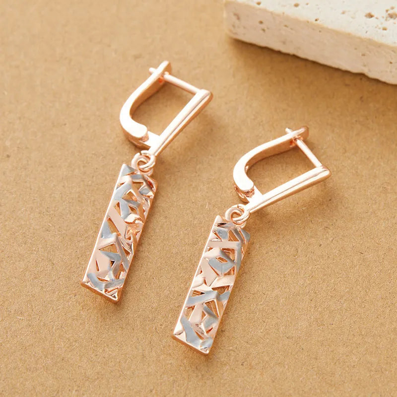 Close-up of women's rectangular hollow two-tone alloy stud earrings on a white background.