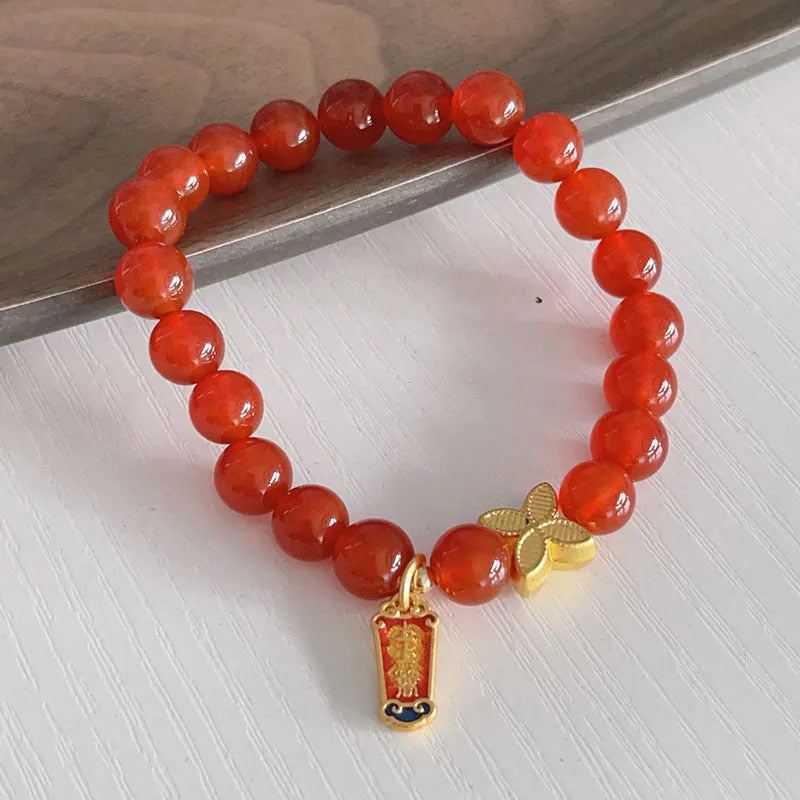 A red agate bracelet for women with Chinese style dragon and lucky bag motifs.