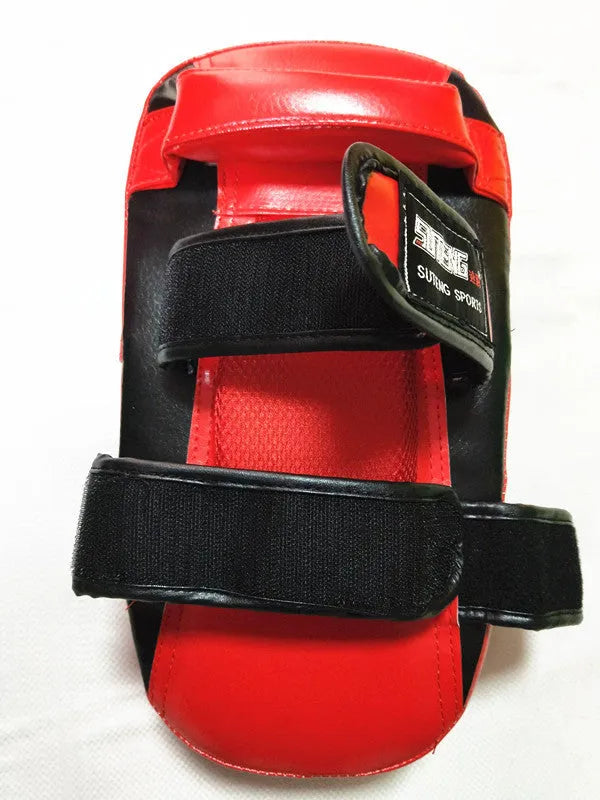 Black and red square hand-held martial arts kick pad with a double buckle strap on the back.