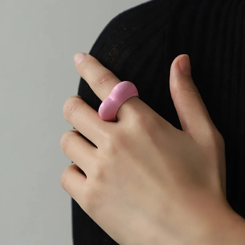 Close-up of a heart-shaped ring with a raised red enamel heart on a metallic band.
