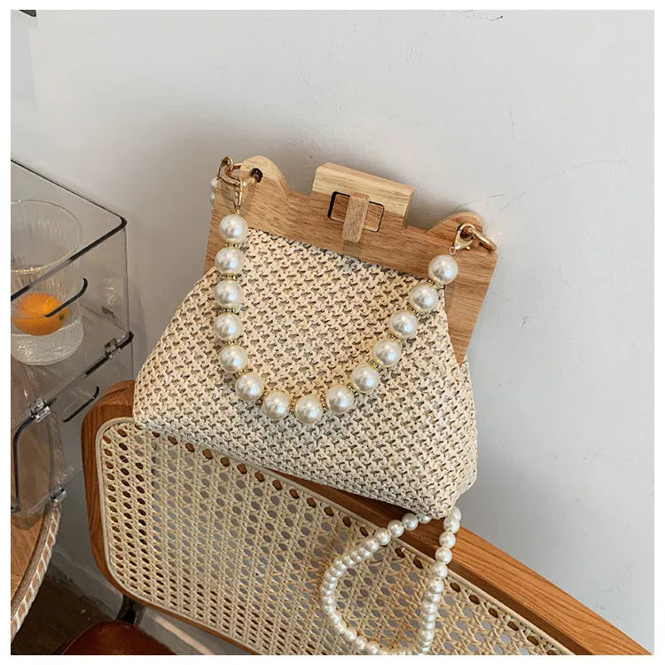 Women's straw shoulder bag with pearl chain strap in beige colour showing organised interior with compartments