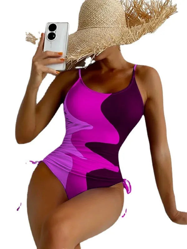 Women's sleeveless backless one-piece swimsuit in a striped pattern, shown in blue.