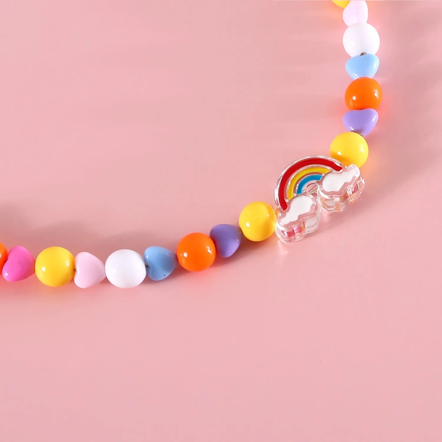 Colourful plastic pearl bead cat necklace with small flower, rainbow, or peach designs on a white background.