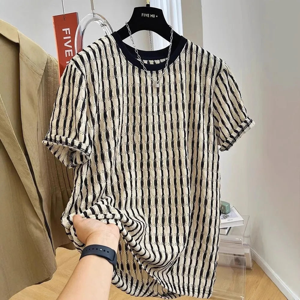 Man wearing a black and white striped loose casual short sleeve shirt made from linen and silk blend.
