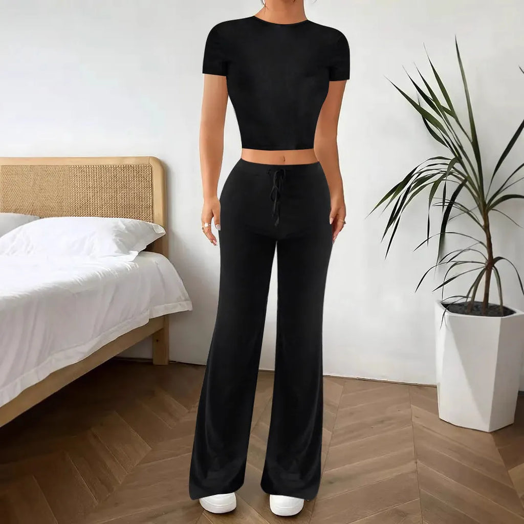 Black women's co-ord set with high waist trousers and regular sleeve T-shirt laid flat