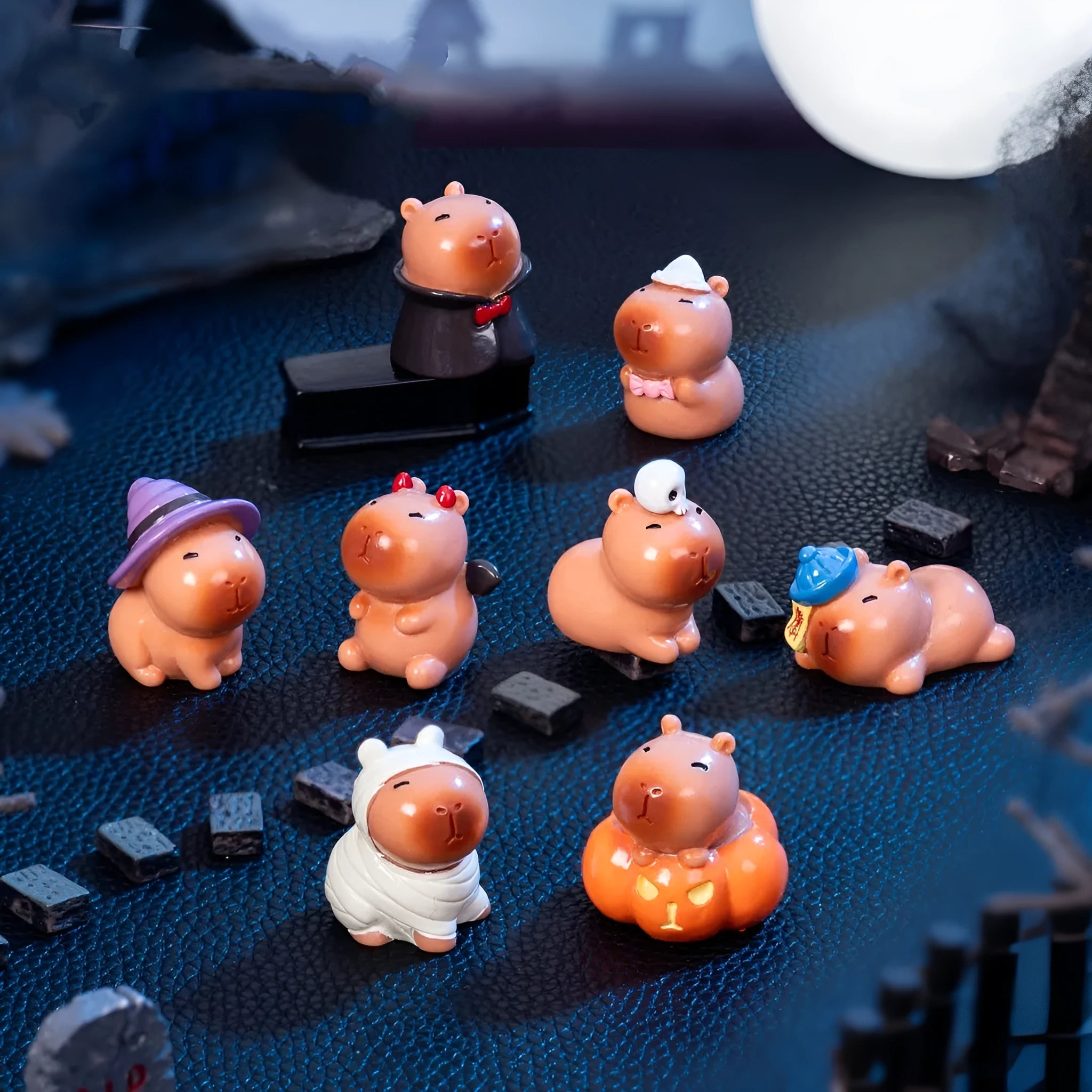 Eight Halloween capybara resin decorations showing pumpkin, zombie, ghost, mummy, vampire, witch hat, devil, and skull designs