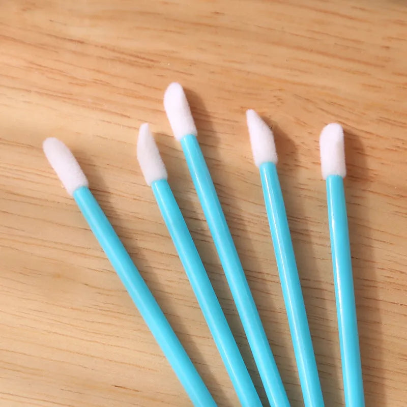 Disposable lip brush applicators with flocked heads in multiple handle colours on white background