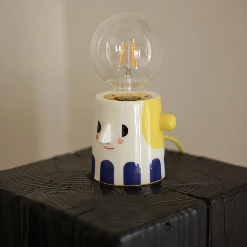 Handmade ceramic table lamp with ball headlight design on bedside table