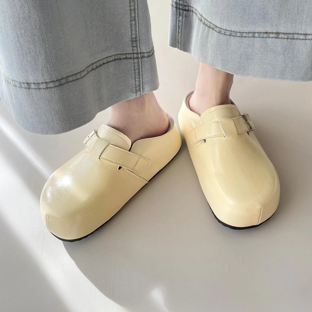 Flat buckle casual sneakers in yellow, black, silver, and creamy-white on a white background.
