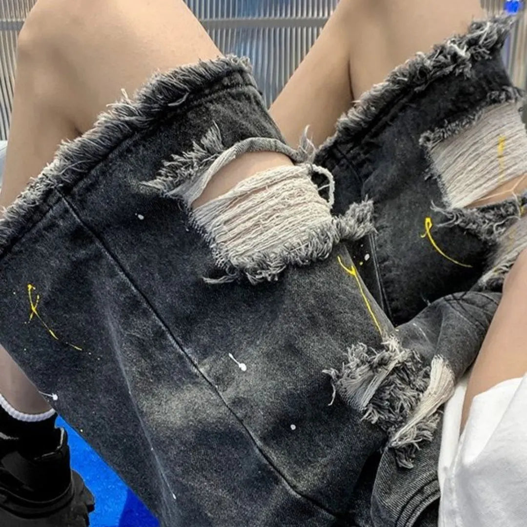 Men's loose-fit denim shorts with water-washed finish and hole detailing in light blue.