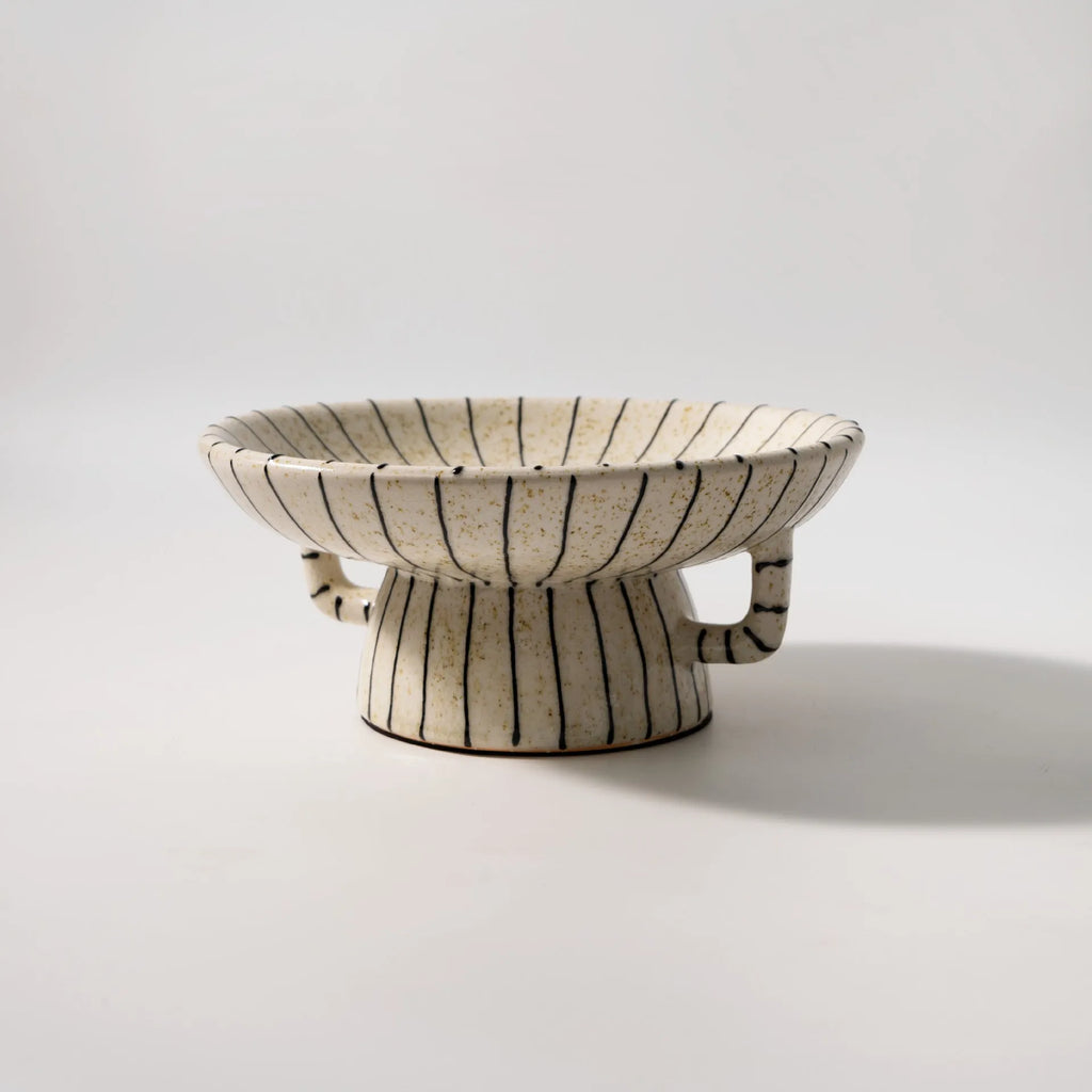 Black and white striped retro-style resin fruit or dessert plate on a table.