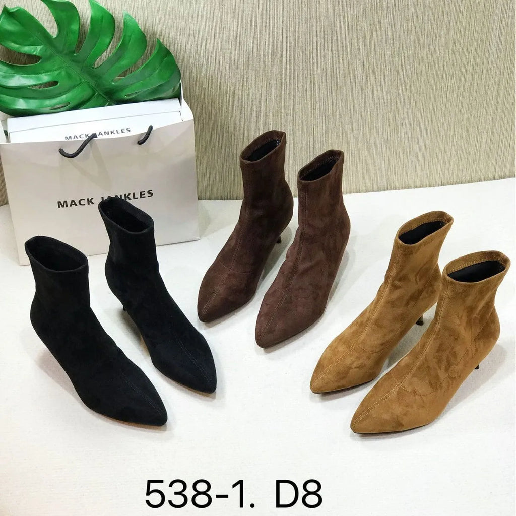 Black pointed toe ankle boots with a stiletto heel on a plain background.