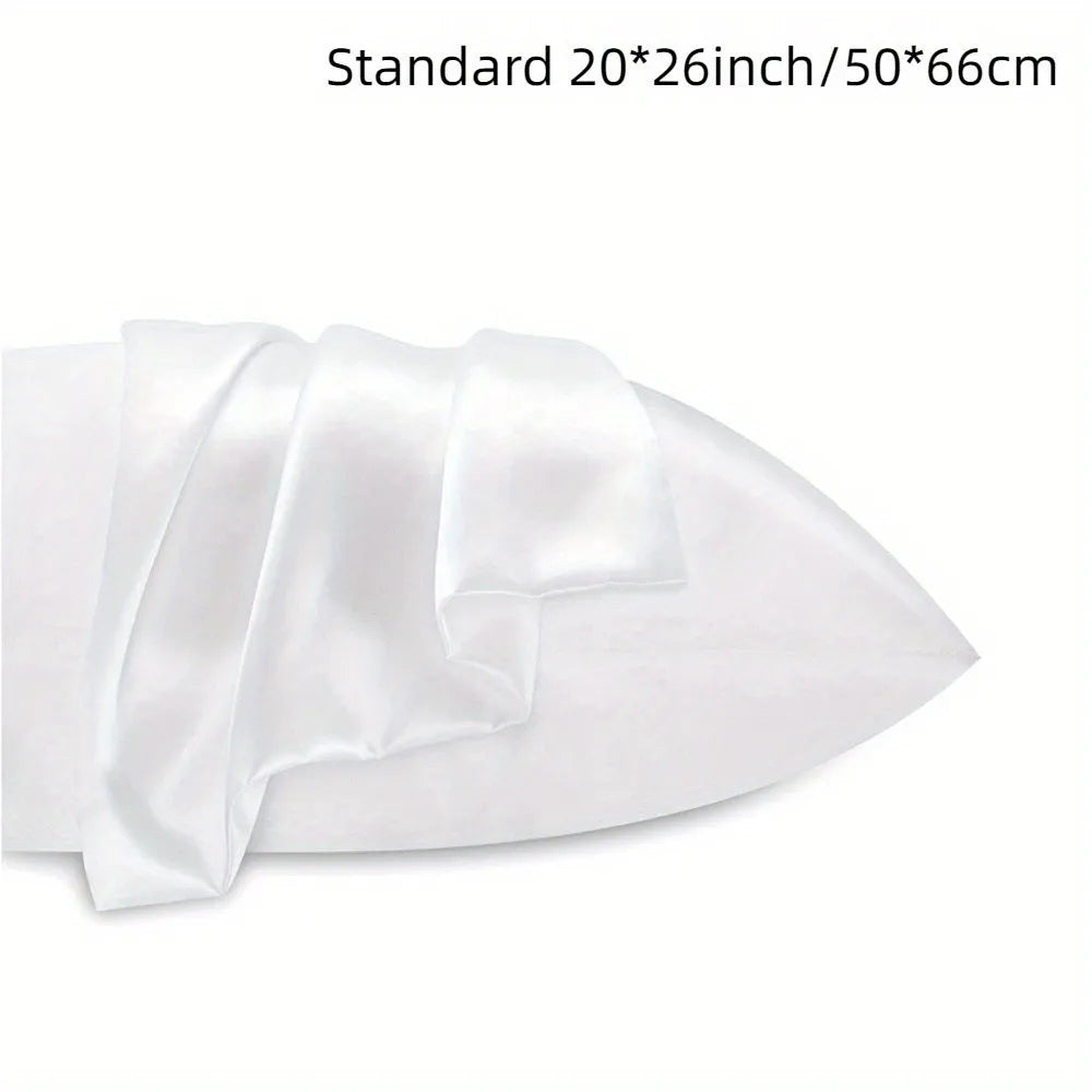 Pair of solid colour satin pillowcases in polyester fabric on a bed.