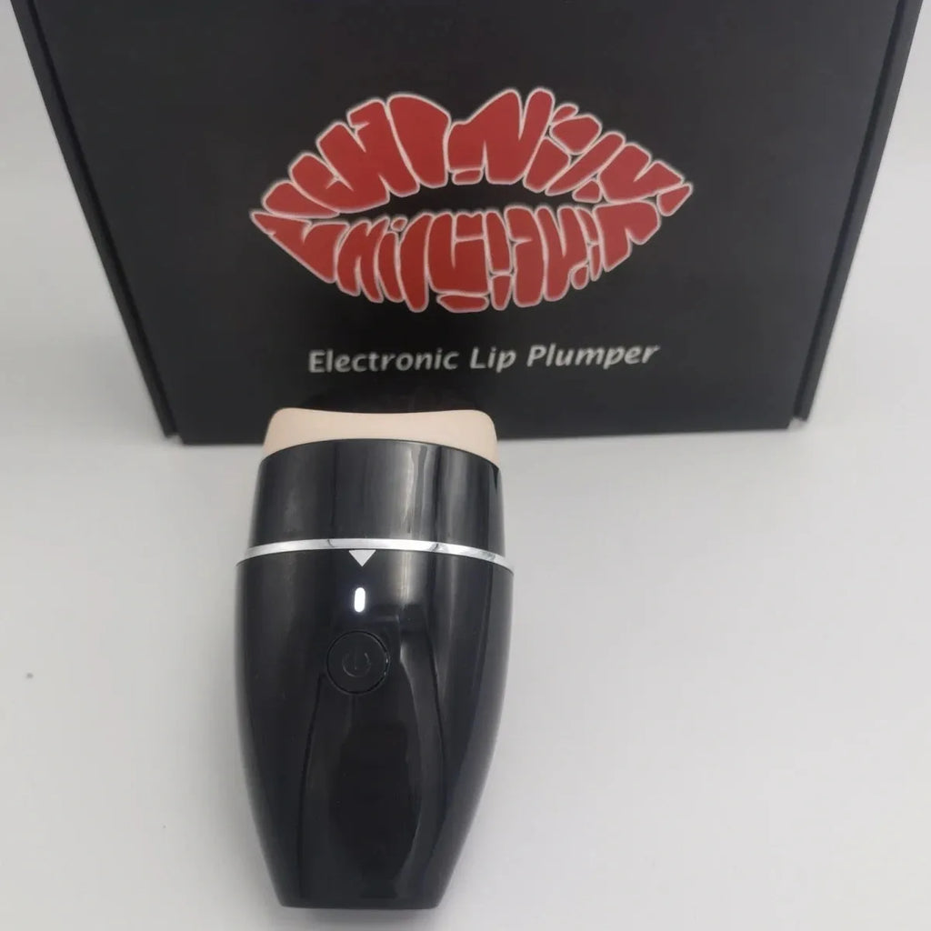 Black electric lip plumper device with a silicone tip next to a white USB charging cable.