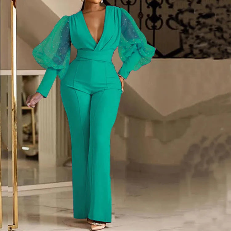 A woman wearing a red wide-leg jumpsuit with long sleeves and an elasticated waist.