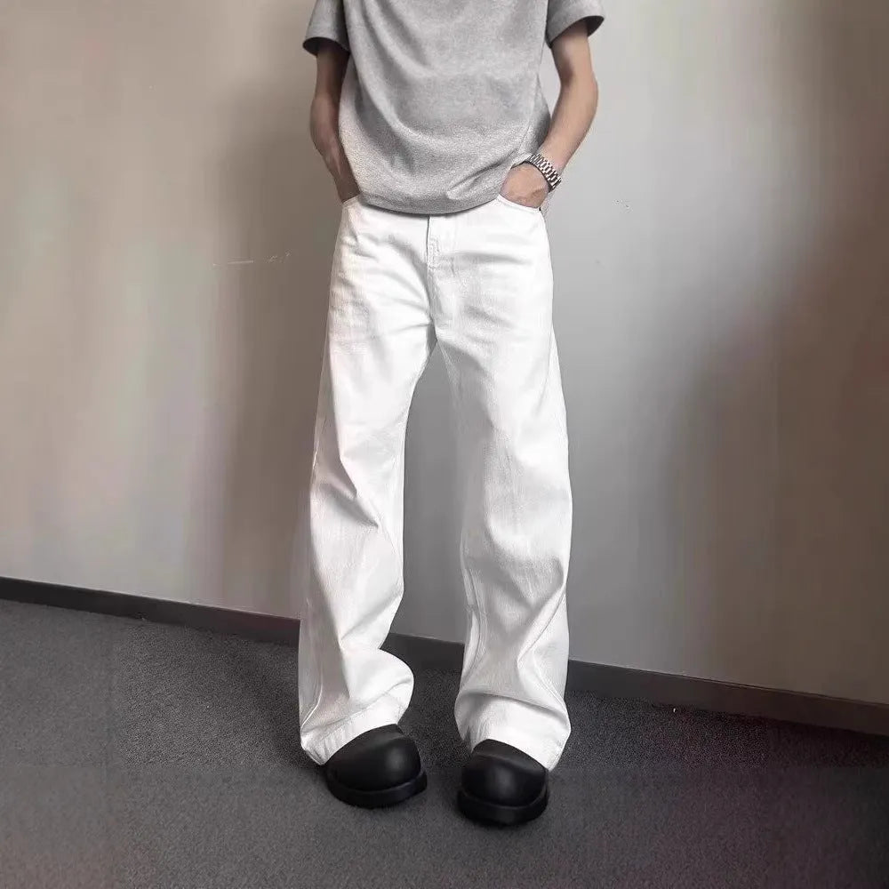 A pair of men's white wide-leg straight jeans with a mid-rise waist and zipper fly on a plain background.