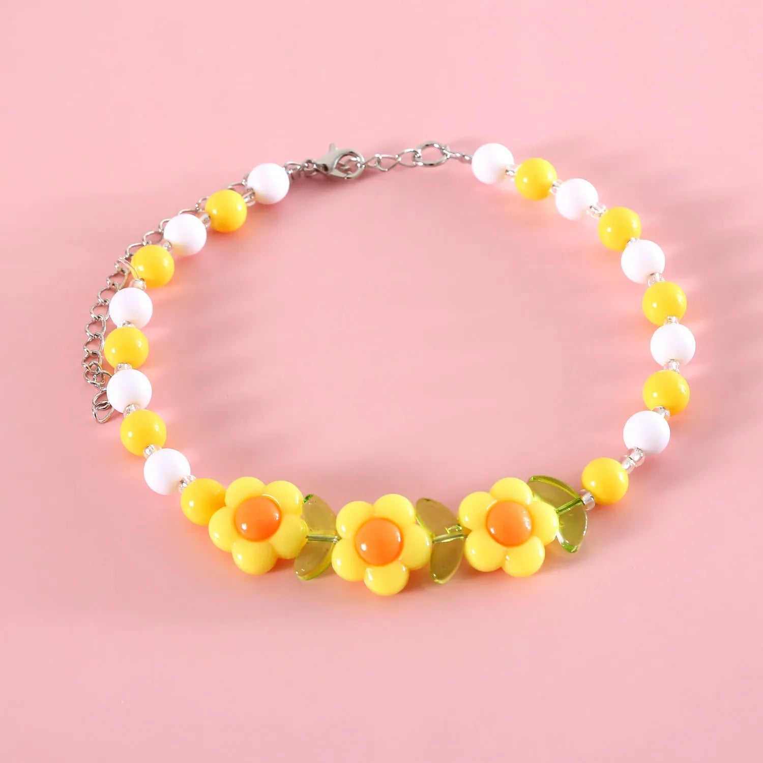 Colourful plastic pearl bead cat necklace with small flower, rainbow, or peach designs on a white background.