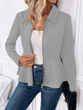 Women's black loose fit coat with beaded zipper and ruffle hem on a hanger.