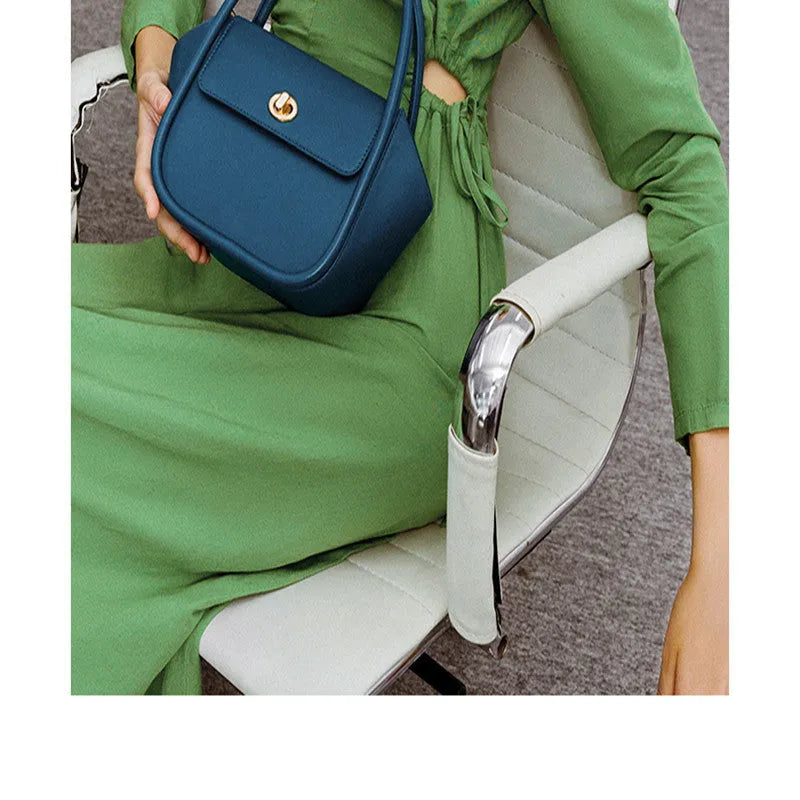 Soft cow leather wing-shaped tote handbag with a buckle and cross-body strap in four colour options.