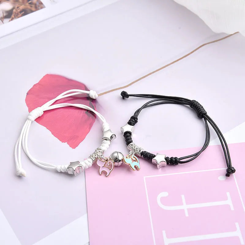 Pair of magnet couple bracelets with suction clasp on wrist, showing alloy designs like crown and love lock.